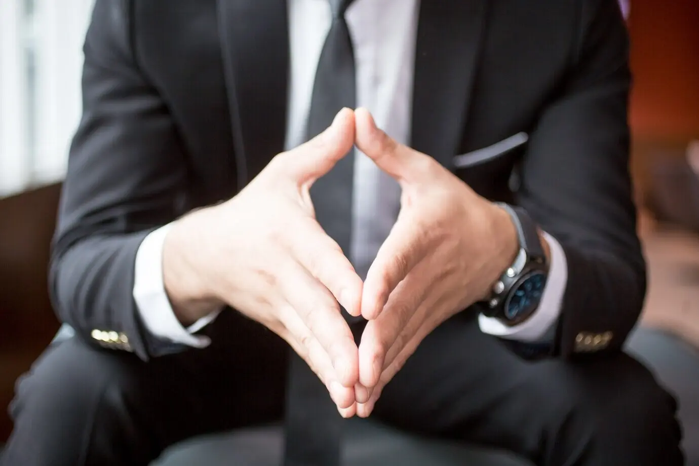 Cropped shot of a boss with hands clasped together.